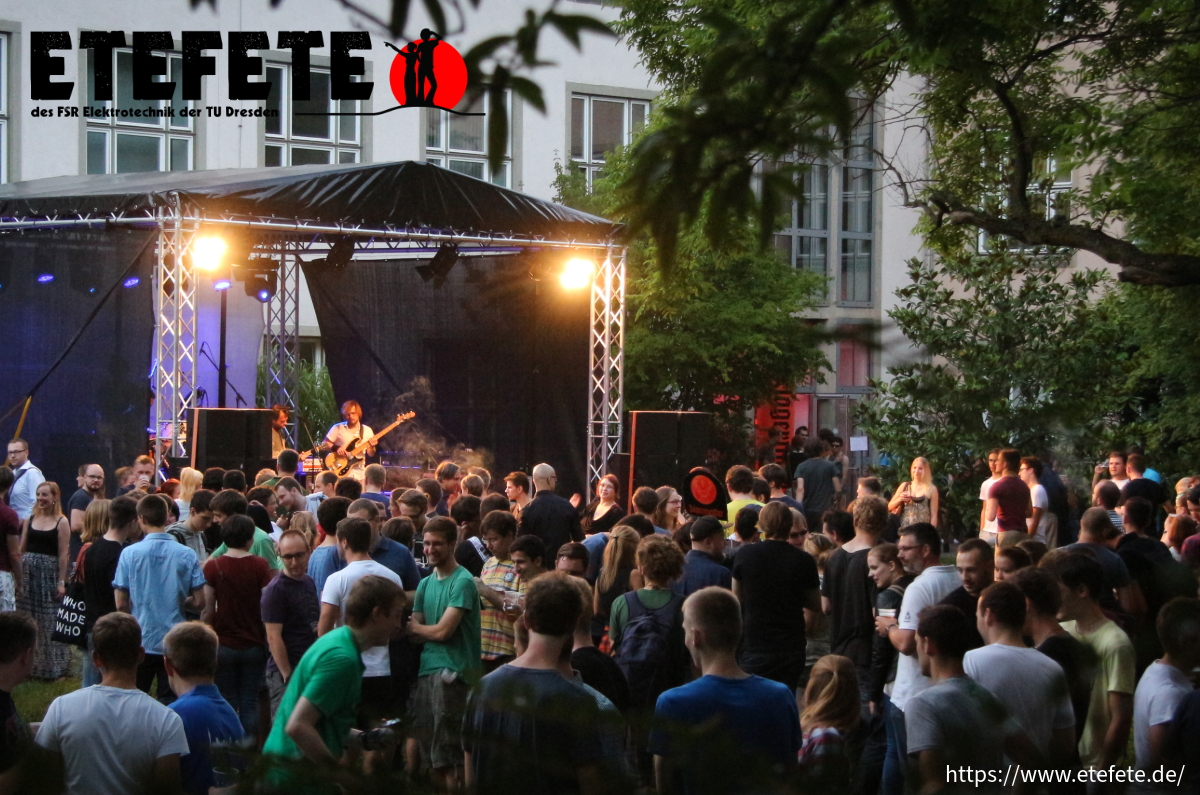 Studierende feiern vor einer Bühne mit Lifeband